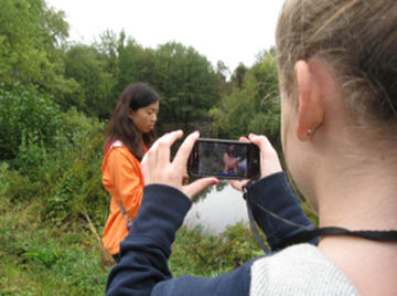 Students using ecoMOBILE on cell phones in a forest.